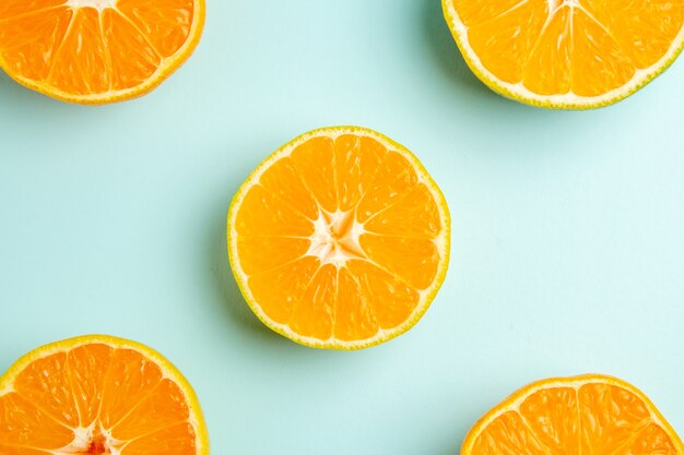 Top view fresh tangerine slices on a light-blue background