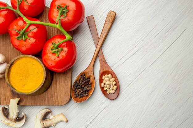 Top view fresh tomato branch turmeric bowl on chopping board