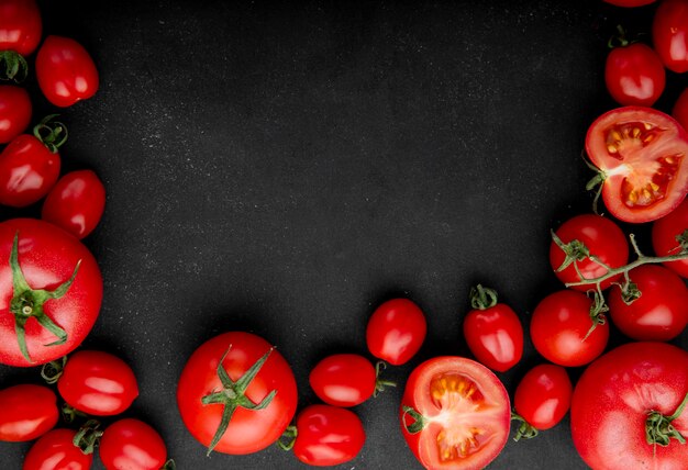 Top view of fresh tomatoes on black background with copy space