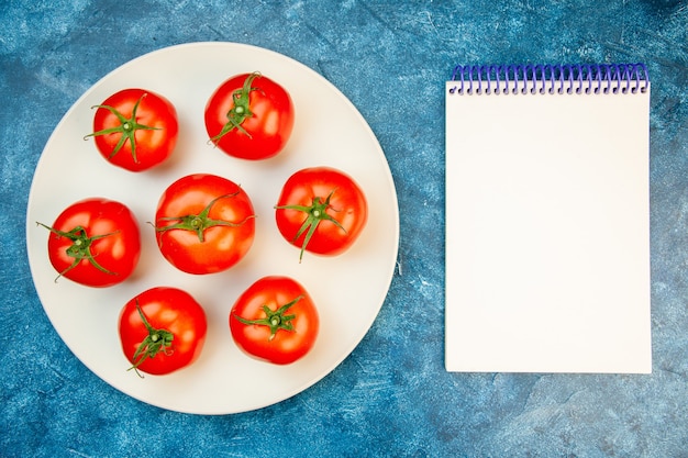 Free photo top view fresh tomatoes inside plate on blue table