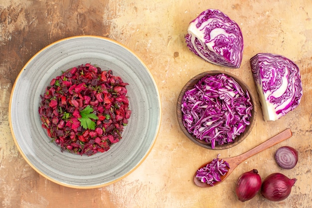 Top view fresh vegetable salad on a ceramic plate made of a bowl of chopped red cabbage and red onions on a wooden background