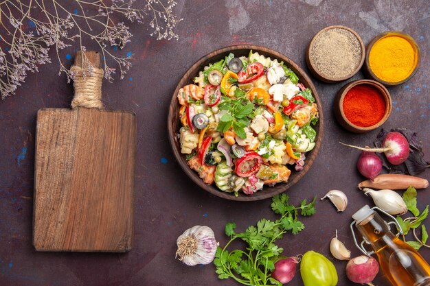 Top view of fresh vegetable. salad with different seasonings on black