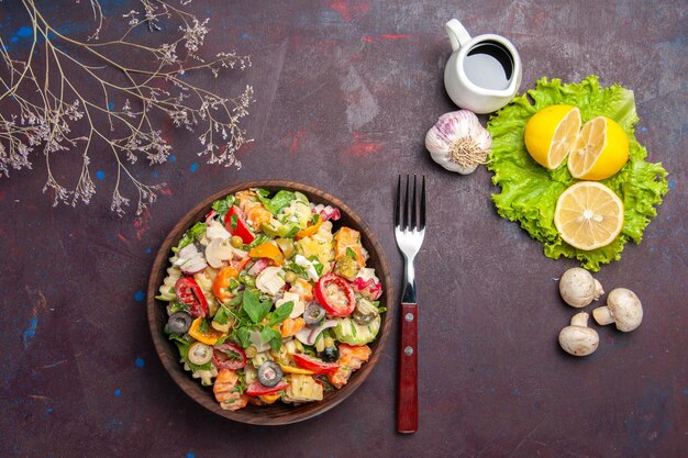 Top view of fresh vegetable. salad with lemon slices and green salad on black table