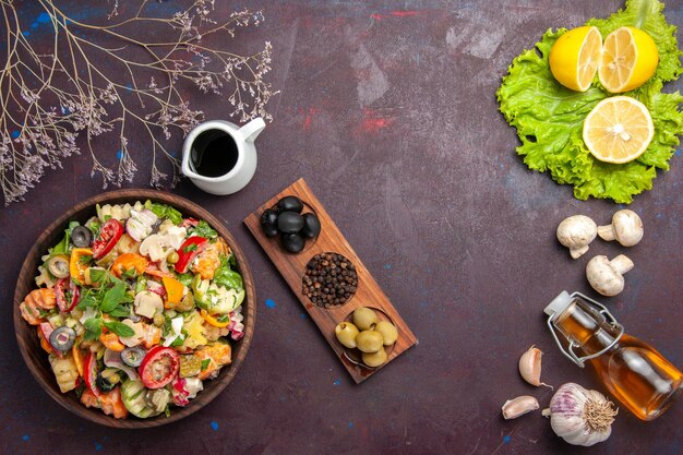 Top view of fresh vegetable. salad with olives and lemon slices on black