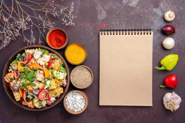 Top view of fresh vegetable salad with seasonings on black