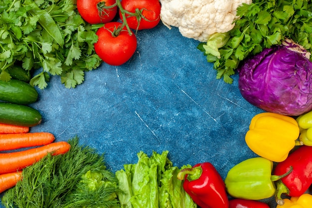 Top view fresh vegetables on blue background free space