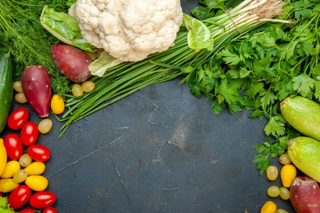 Top view fresh vegetables cherry tomatoes cumcuat cauliflower parsley zucchini dill free space