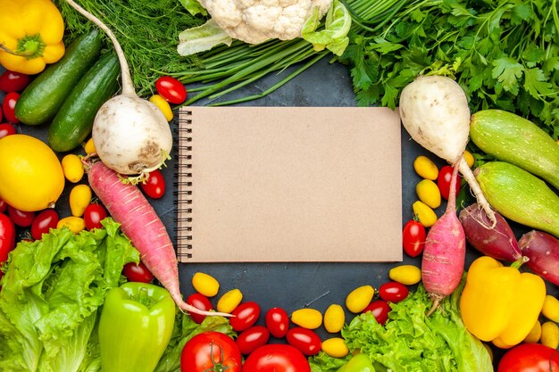 Top view fresh vegetables cherry tomatoes cumcuat lettuce dill yellow bell pepper cucumber zucchini notepad in center