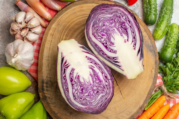 Top view fresh vegetables composition with sliced red cabbage on white background