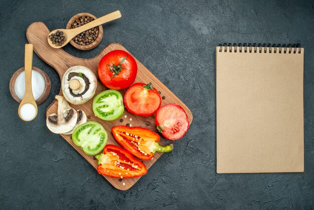 Top view fresh vegetables mushrooms red and green tomatoes cut bell peppers on cutting board