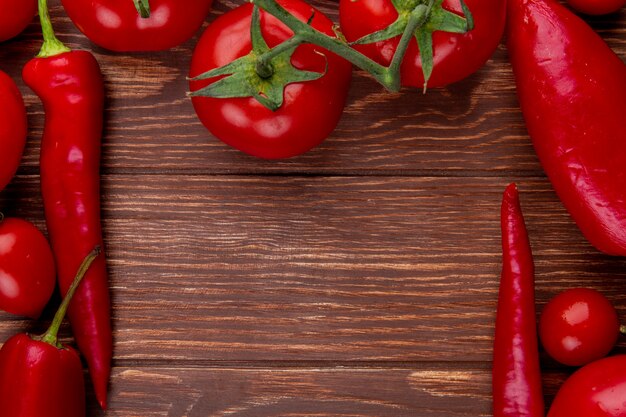 Top view of fresh vegetables ripe tomatoes with red chili peppers on rustic wood with copy space