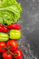 Free photo top view fresh vegetables tomatoes green and red bell peppers lettuce on dark surface free place