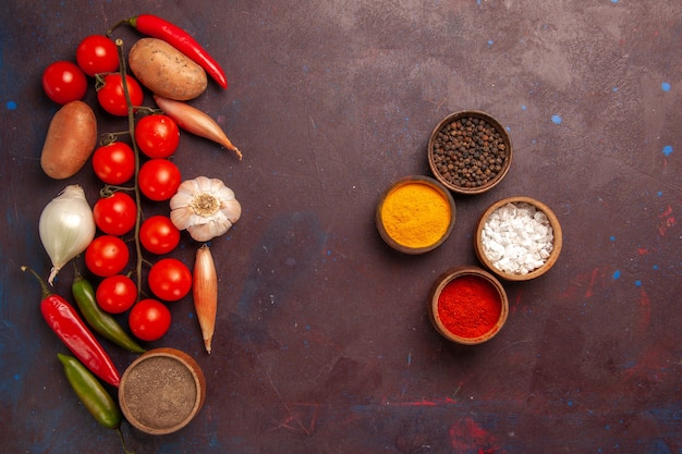 Top view fresh vegetables with different seasonings and pasta on dark space