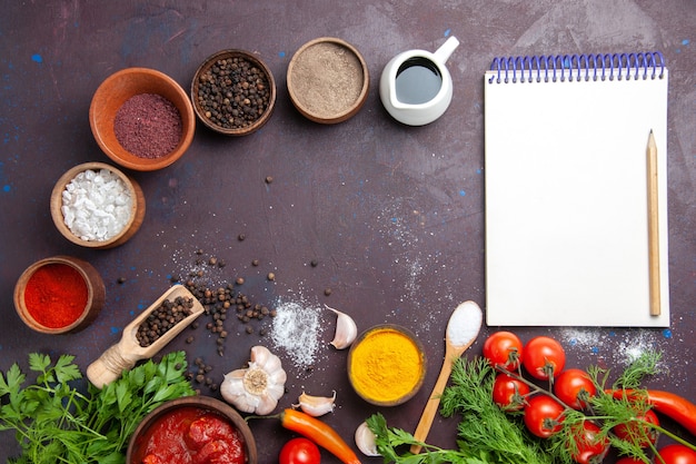 Free photo top view fresh vegetables with greens and seasonings on dark space