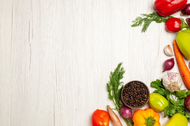 Top view of fresh vegetables with greens on white