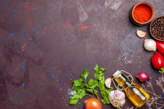 Top view of fresh vegetables with seasonings on black. table