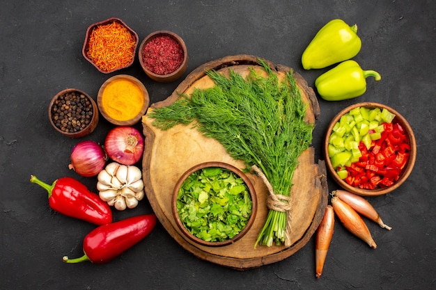 Top view fresh vegetables with seasonings and greens on dark surface salad health ripe meal vegetable