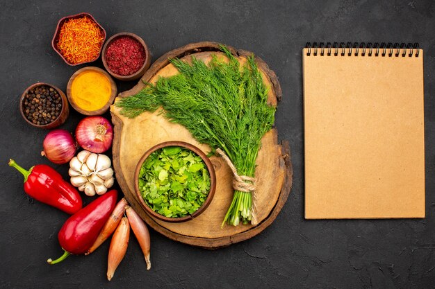 Top view fresh vegetables with seasonings and greens on the dark surface salad health ripe meal vegetable