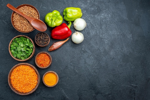 Top view fresh vegetables with seasonings on grey space