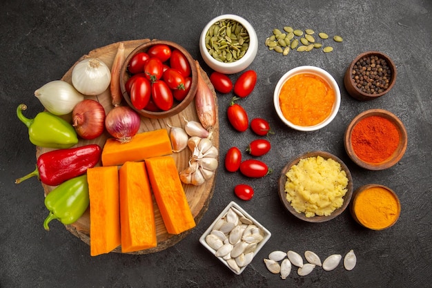 Free photo top view fresh vegetables with sliced pumpkin and garlic on a grey background color seed fresh ripe salad