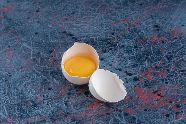 Free photo top view of fresh white chicken egg broken with yolk and egg white .