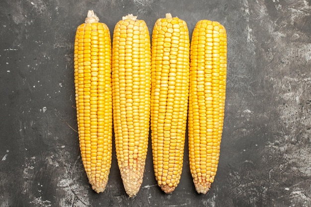 Top view fresh yellow corns on dark background