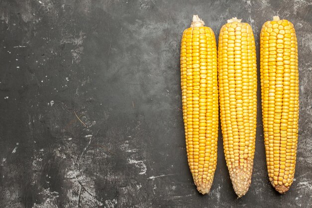 Top view fresh yellow corns on dark background