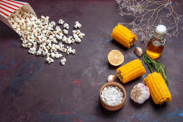 Free photo top view fresh yellow corns with popcorn on dark desk corn snack food raw fresh