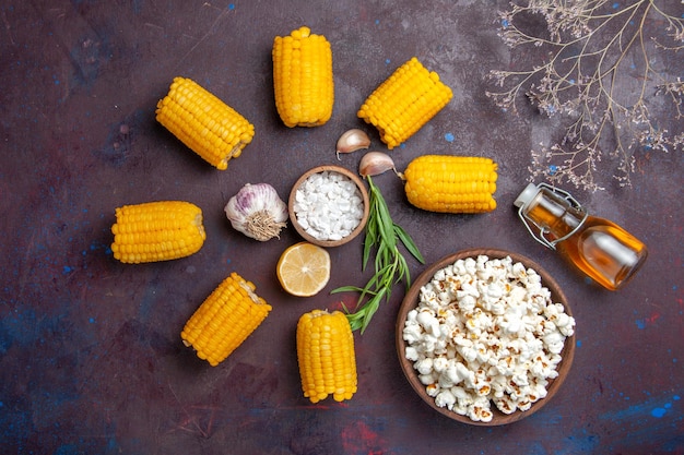 Top view fresh yellow corns with popcorn on dark surface corn snack food raw fresh