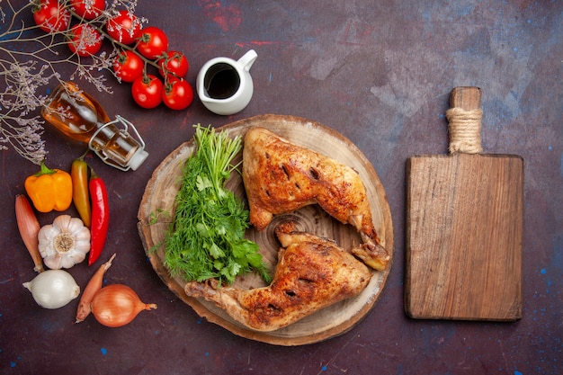 Free photo top view fried chicken with greens and vegetables on dark desk