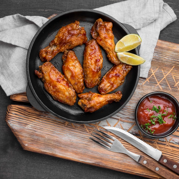 Top view of fried chicken with sauce and cutlery