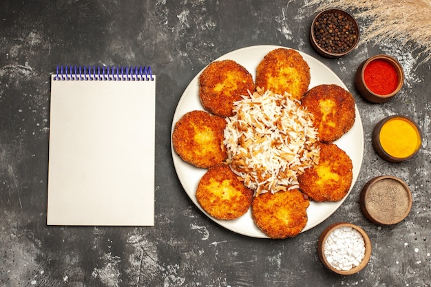 Free Photo top view fried cutlets with cooked rice and seasonings on dark desk food dish photo meat