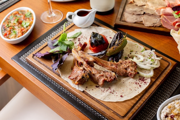 A top view fried meat bones with fried vegetables and sauce on the table food meal dinner restaurant meat