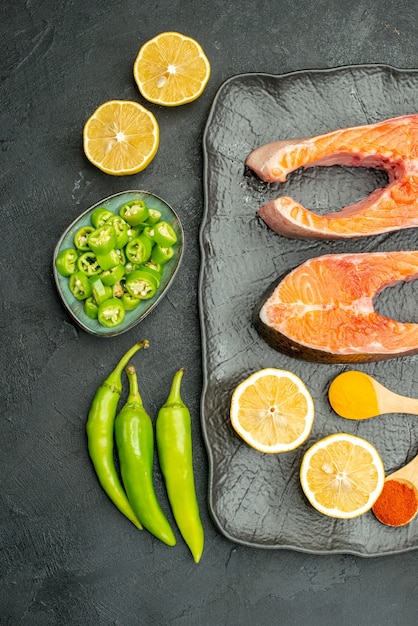 Free Photo top view fried meat slices with peppers and lemon on a dark background