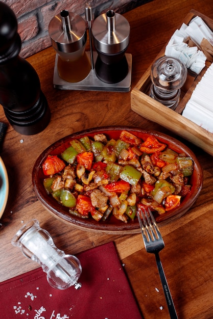 Top view of fried meat and vegetables on a wooden table