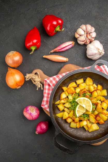 Free photo top view fried potatoes inside pan with lemon on dark background