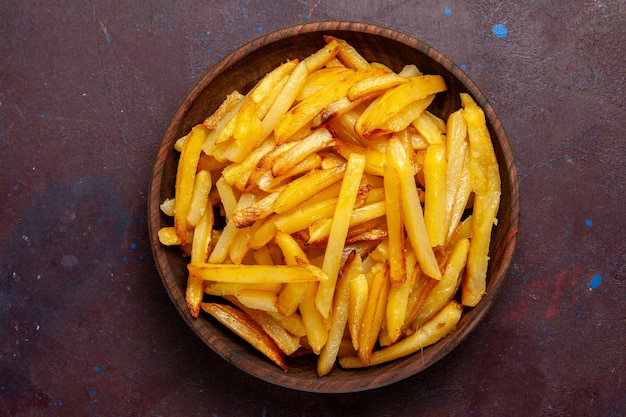 Top view fried potatoes tasty french fries inside plate on dark surface