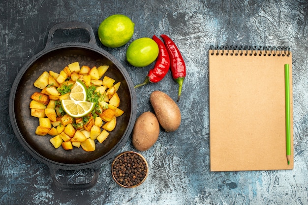 Free Photo top view fried potatoes with lemon and peppers on light-grey background