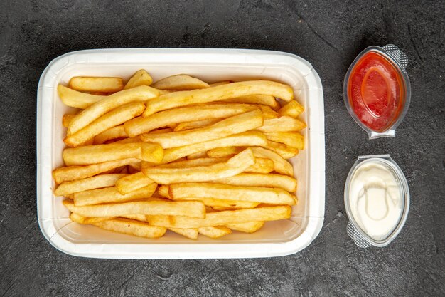 Top view of fried potatoes with potatoes served with ketchup and mayonnaise