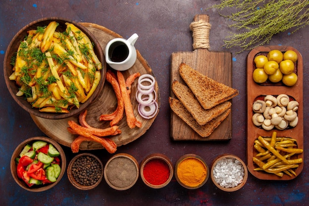 Top view fried potatoes with seasonings bread and different vegetables on dark surface