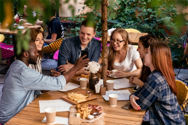 Top view of a friendly meeting of a college students in their free time at the cozy restaurant