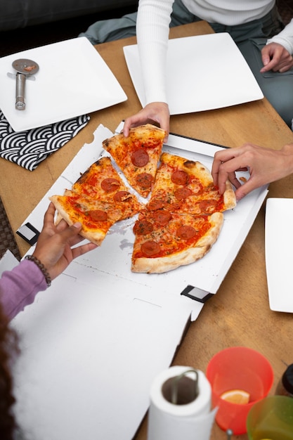 Free photo top view friends eating delicious pizza