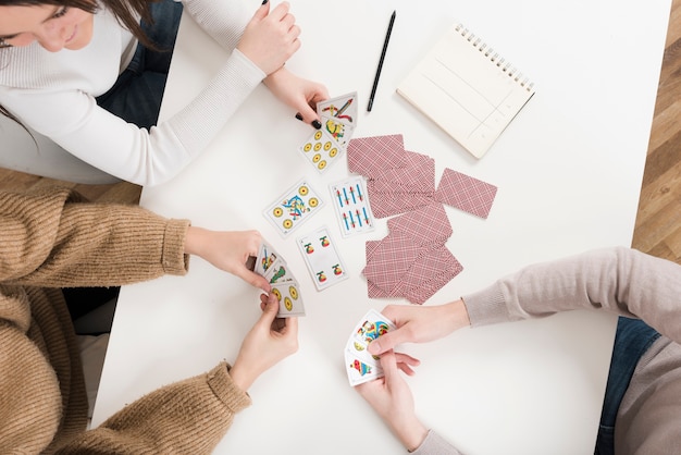 Top view friends playing cards game