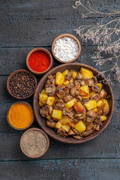 Free Photo top view from afar bowl with food bowl with mushrooms and potatoes different spices around it next to the tree branches