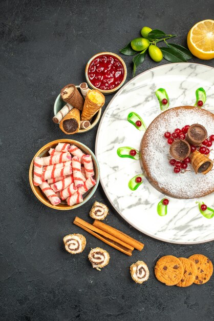 Top view from afar a cake a cake with berries cinnamon jam cookies sweets