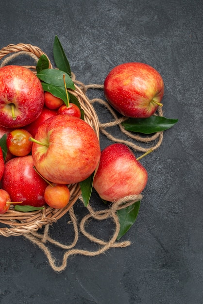 Free Photo top view from afar fruits basket of the appetizing cherries and apples with leaves