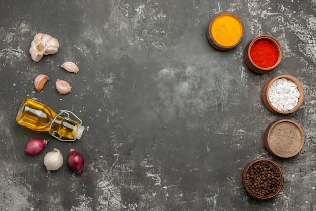 Top view from afar spices colorful spices onion garlic bottle of oil