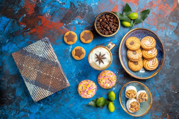 Top view from afar sweets the appetizing cookies coffee beans in bowl citrus fruits tablecloth