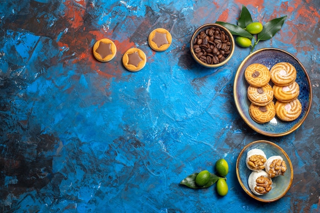 Top view from afar sweets different cookies coffee beans citrus fruits