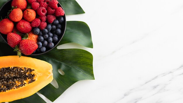 Top view of fruit bowl with papaya and copy space